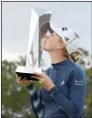  ??  ?? Jessica Korda kisses the championsh­ip trophy on the 18th green after winning in a one-hole playoff against Danielle Kang during the final round of the Tournament of Champions LPGA golf tournament, on Jan 24, in Lake Buena Vista, Fla. (AP)