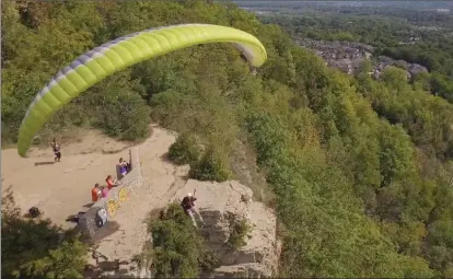  ??  ?? A video taken by a drone operator shows a paraglider taking off from Dundas Peak last week.