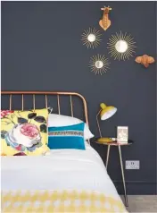  ??  ?? GUEST BEDROOM A dark grey feature wall creates a dramatic backdrop for metallic furnishing­s and vibrant cushions. Alana copper double bed, £399; Alana bedside table, £99, both Made.com