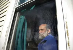  ??  ?? US Navy veteran Stephen Matthews sits for a photograph in the bedroom of a relative’s home in Warwick, where he and his family lived after being evicted from their home. — AP