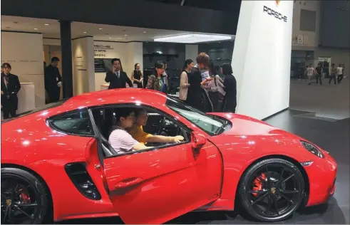  ?? LI FUSHENG / CHINA DAILY ?? Visitors examine a Porsche model at the Guangzhou auto show. China’s premium vehicle segment is expected to see further growth thanks to ongoing consumptio­n upgrades, despite concerns of a fall in the overall market.