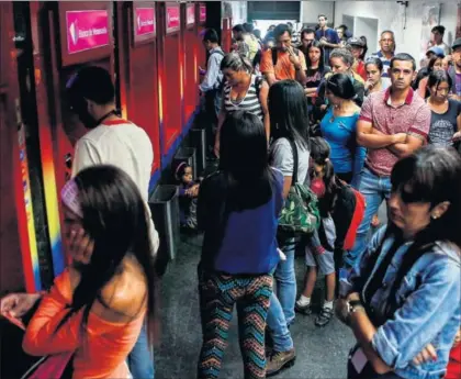  ??  ?? Cola ante unos cajeros automático­s, ayer en Caracas.