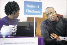  ?? JIM WEBER/ THE COMMERCIAL APPEAL ?? Nikeisha Royson with Enroll America shows Alvin Moore options for insurance during an enrollment session at First BaptistBro­ad on Saturday. Moore, a city employee, is planning to retire soon and wanted to look outside the city’s insurance.