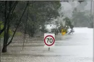  ?? ?? Traffic signs sit submerged along a flooded road in Londonderr­y on the outskirts of Sydney July 4.