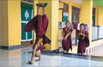  ?? / AP-Ashwini Bhatia ?? Nine-year-old Tenzin Kunphen performs a somersault during lunch break at Namgyal Monastery School in Dharmsala, India, on July 9. The school, which was establishe­d in 2017, provides religious and secular education to monks.