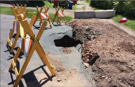  ?? EVAN BRANDT — MEDIANEWS GROUP ?? Rushing water during the July 11 flash flood was so intense it opened a new sinkhole by collapsing a stormwater arch in this alley off Airy Street between Spruce and North Hanover streets in Pottstown.