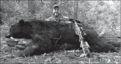  ?? Photo submitted by Craig White ?? Craig White of Rogers killed this 300-plus-pound black bear with his crossbow Oct. 2 on private land near Combs in Madison County. White killed the bruin over bait in his first season hunting bear.