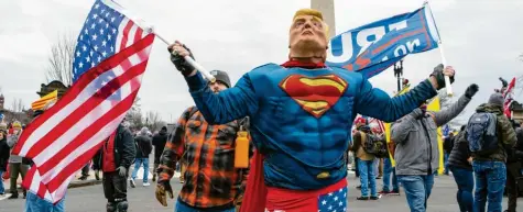  ?? Foto: Jose Luis Magana, dpa ?? Seine Fans posieren so, wie Donald Trump sich selbst sah: als Superman. Doch Demokratie ist kein Spiel, kein Spektakel, kein Witz.