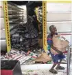  ?? — AFP ?? A young boy collects food and drinks from a burnt down and looted Auchan supermarke­t in the up-market area of Almadies in Dakar.