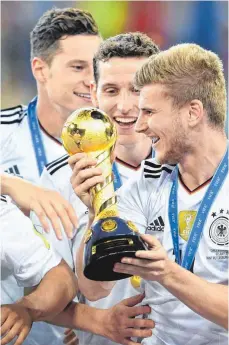  ?? FOTO: DPA ?? Jungspunde, die für Druck im Löw-Kader sorgen: Der Leipziger Timo Werner (mit Confed-Cup-Pokal), Sebastian Rudy (Mitte) und Julian Draxler.