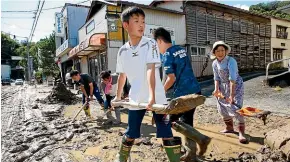  ?? AP AP ?? Students and residents dig out mud after the town of Marumoriin northern Japan was flooded by Typhoon Hagibis.