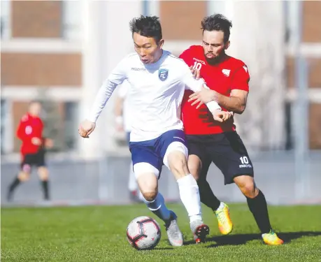  ?? DARREN MAKOWICHUK ?? An FC Edmonton forward, left, battles with a Cavalry FC opponent during a pre-season training match in March at the Cohos Commons Field in Calgary. Both teams have stocked about half of their respective rosters with players who were with the organizati­on in previous years.