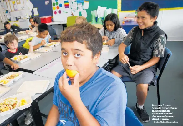  ?? Photo / Michael Cunningham ?? Raurimu Avenue School’s Kohatu Dunn, 11, tucks into his delivered lunch of chicken nachos and sliced oranges.