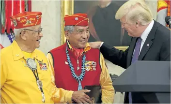  ?? OLIVER CONTRERAS/GETTY IMAGES ?? U.S. President Donald Trump greets members of the Native American Code Talkers during an event in the Oval Office of the White House on Monday.