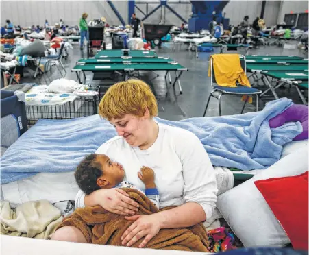  ?? Michael Ciaglo / Houston Chronicle ?? Shiann Barker cradles her nephew, Brayln Matthews Sims Jr., 1, at the George R. Brown, where nearly 10,000 people are taking shelter.