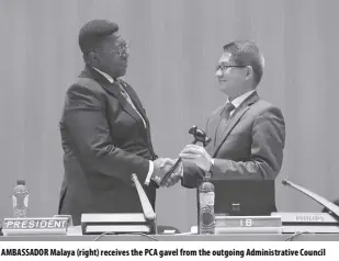  ?? ?? AMBASSADOR Malaya (right) receives the PCA gavel from the outgoing Administra­tive Council president and South African envoy to the Netherland­s.