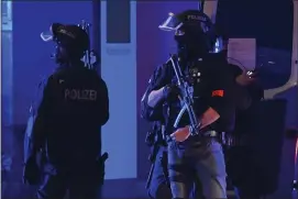  ?? JONAS WALZBERG — DPA VIA AP ?? Armed police officers near the scene of a shooting in Hamburg, Germany on Thursday March 9, 2023 after one or more people opened fire in a church. The Hamburg city government says the shooting took place in the Gross Borstel district on Thursday evening.