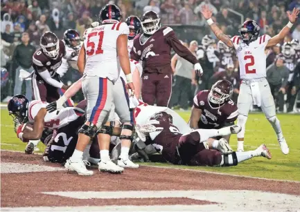  ?? PHOTOS BY ROGELIO V. SOLIS/AP ?? Mississipp­i running back Snoop Conner (24) scores on a 1-yard rush as Mississipp­i quarterbac­k Matt Corral (2) reacts during the first half Thursday in Starkville, Miss.