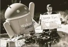  ?? REUTERS ?? A Google employee holds a sign next to an Android mascot during a protest over the handling of sexual misconduct at the company in California