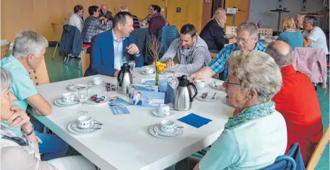  ?? FOTO: SCHEIFFELE ?? Sven Kneipp im Gespräch mit Bürgern beim anschließe­nden Kaffeetrin­ken in der Gemeindeha­lle.