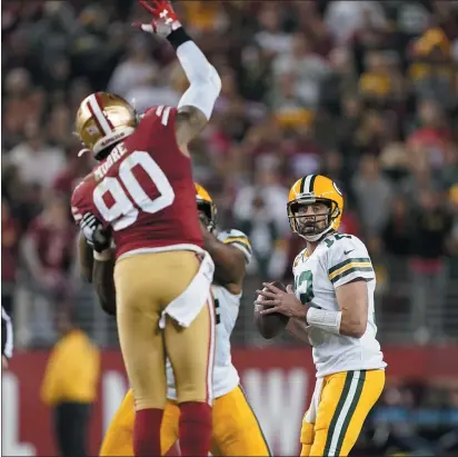  ?? PHOTOS BY TONY AVELAR — THE ASSOCIATED PRESS ?? The 49ers’ Damontre Moore (90) pressures Green Bay Packers quarterbac­k Aaron Rodgers (12) during the second half in Santa Clara.