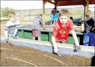  ?? Lynn Atkins/The Weekly Vista ?? Rhett Nading (left) and Cooper Mayhew smooth top soil in one of the Cooper beds when their ESTEAM class had a turn in the community garden. The garden, behind the Mercy Clinic, is shared by Mercy, Cooper Elementary and a new community group.