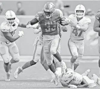  ?? JOHN MCCALL/SUN SENTINEL ?? Lions running back Kerryon Johnson breaks away from Dolphins linebacker Raekwon McMillan for a big gain.