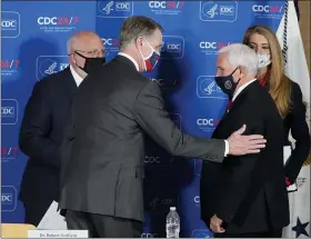  ?? JOHN BAZEMORE -ASSOCIATED PRESS ?? Vice President Mike Pence, right, speaks with Sen. David Perdue, R-Ga., and Sen. Kelly Loeffler, R-Ga, as Centers for Disease Control and Prevention director Dr. Robert Redfield looks on after a meeting on COVID-19 at the CDC Friday, in Atlanta.