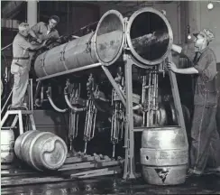  ?? THE MILWAUKEE JOURNAL ?? Workers prepare a keg-filling line at Blatz Brewing Co. on July 27, 1953, after a 76-day strike at six Milwaukee breweries ended with a settlement.