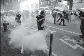  ?? AP/KIN CHEUNG ?? People run for cover from police tear-gas shells Friday during a protest in Hong Kong.