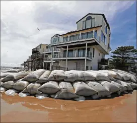  ?? CHUCK BURTON / ASSOCIATED PRESS ?? Sand bags surround homes on North Topsail Beach, N.C., on Wednesday as Hurricane Florence threatens the Carolinas coast.