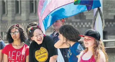  ?? ANDREW FRANCIS WALLACE PHOTOS/TORONTO STAR ?? Kids take part in the flag-raising ceremony to mark Internatio­nal Day Against Homophobia, Transphobi­a and Biphobia.