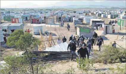  ?? Photo Brenton Geach/gallo Images ?? Who’s illegal? Cape Town police officers monitor the demolition of alleged illegal structures by the anti-land invasion unit in 2018 in Makhaza. It happened again during lockdown.