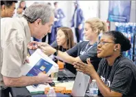  ?? AP PHOTO/ELAINE THOMPSON ?? Jamie Rubinstein, left, first in a line of applicants, talks with Amazon worker Vanessa Chandler as he begins the recruitmen­t process at a job fair Wednesday at an Amazon fulfillmen­t center in Kent, Wash. Amazon plans to make thousands of job offers on...