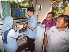  ??  ?? MUHAMMAD Faiz menunjukka­n bekalan udang sejuk beku berkualiti tinggi di tapak Projek AQUA/Ternakan Udang.