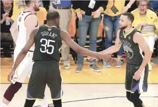  ?? AP ?? Stephen Curry y kevin Durant se felicitan luego del segundo triunfo de los Guereros el domingo en la final de la NBA.