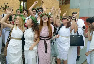  ??  ?? Toga party Anche ieri (a fianco) gli studenti del Maffei hanno festeggiat­o l’ultimo giorno di scuola in abbigliame­nto «classico». Sopra, bagno in Arsenale (Sartori)