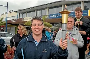  ?? RENEE CLAYTON/STUFF ?? Stephen Just holds the Olympic torch.