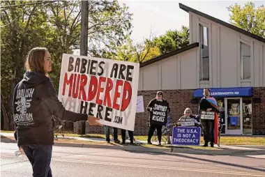  ?? Charlie Riedel/Associated Press ?? Demonstrat­ors for and against abortion rights protest outside the Kansas City Planned Parenthood clinic. It and others in Kansas have been inundated, able to take only 10 to 15 percent of patients seeking abortions.