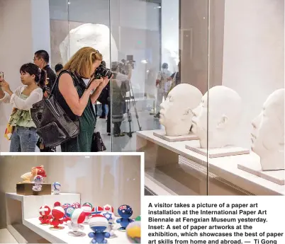  ??  ?? A visitor takes a picture of a paper art installati­on at the Internatio­nal Paper Art Biennale at Fengxian Museum yesterday. Inset: A set of paper artworks at the exhibition, which showcases the best of paper art skills from home and abroad. — Ti Gong