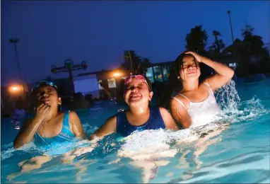  ?? RECORDER PHOTOS BY CHIEKO HARA ?? Cousins Kaylie Angeles, 9, left, Celeste Angeles, 7, and Evelyn Angeles, 11, right, all emerge from the water at the same time Friday, Aug. 3 at the Dive-in Theater hosted by the City’s Parks and Leisure at the City Pool. The event filled the pool to maximum capacity.