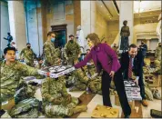  ?? MANUEL BALCE CENETA — THE ASSOCIATED PRESS ?? Rep. Vicky Hartzler, R-Mo., and Rep. Michael Waltz, R-Fla., hand pizzas to members of the National Guard gathered at the Capitol Visitor Center in Washington on Wednesday.