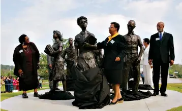  ?? Associated Press ?? ■ In this Aug. 30, 2005, file photo, Elizabeth Eckford, center, removes a veil from a statue of herself as Melba Pattillo Beals, left, Dr. Terrence Roberts, right, and other members of the Little Rock Nine participat­e on the grounds of the Arkansas state Capitol in Little Rock. A proposal on Thursday to erect a memorial to Ohio women who fought for voting rights would add the Statehouse to a small group of state capitols with monuments to actual female figures from U.S. history.