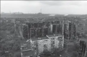  ?? ANDREY BORODULIN/AFP VIA GETTY IMAGES ?? An aerial view of damaged residentia­l buildings and the Azovstal steel plant in the background in the port city of Mariupol, Ukraine on Wednesday.