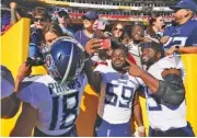  ?? AP PHOTO/ALEX BRANDON ?? From left, Tennessee Titans wide receiver Kyle Philips, defensive tackle Sam Okuayinonu and tight end Chigoziem Okonkwo celebrate with fans after defeating the host Washington Commanders 21-17 on Oct. 9.