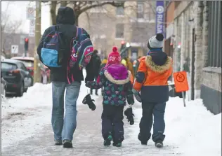  ?? CP PHOTO PAUL CHIASSON ?? Parents walk their children to school as primary schools reopen following the Christmas break amid the COVID-19 pandemic in Montreal, on Monday.