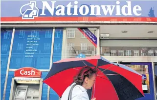  ?? REUTERS ?? A woman walks past a branch of the Nationwide Building Society in London.