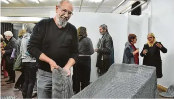  ??  ?? Bernd Rummert mit dem Werk „sicher ist sicher“. Die Decke aus Federringe­n besteht aus fast 300 000 Teilen.