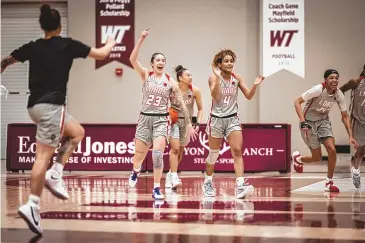  ?? COURTESY OF UNM ATHLETICS ?? UNM’s Jaedyn De La Cerda (23) and LaTascya Duff (4) celebrate along with the rest of the Lobos after their win over Fresno State on Thursday night.