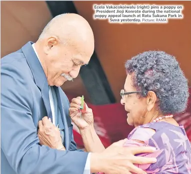 ?? Picture: RAMA ?? Ecela Vakacokoiw­alu (right) pins a poppy on President Jioji Konrote during the national poppy appeal launch at Ratu Sukuna Park in Suva yesterday.